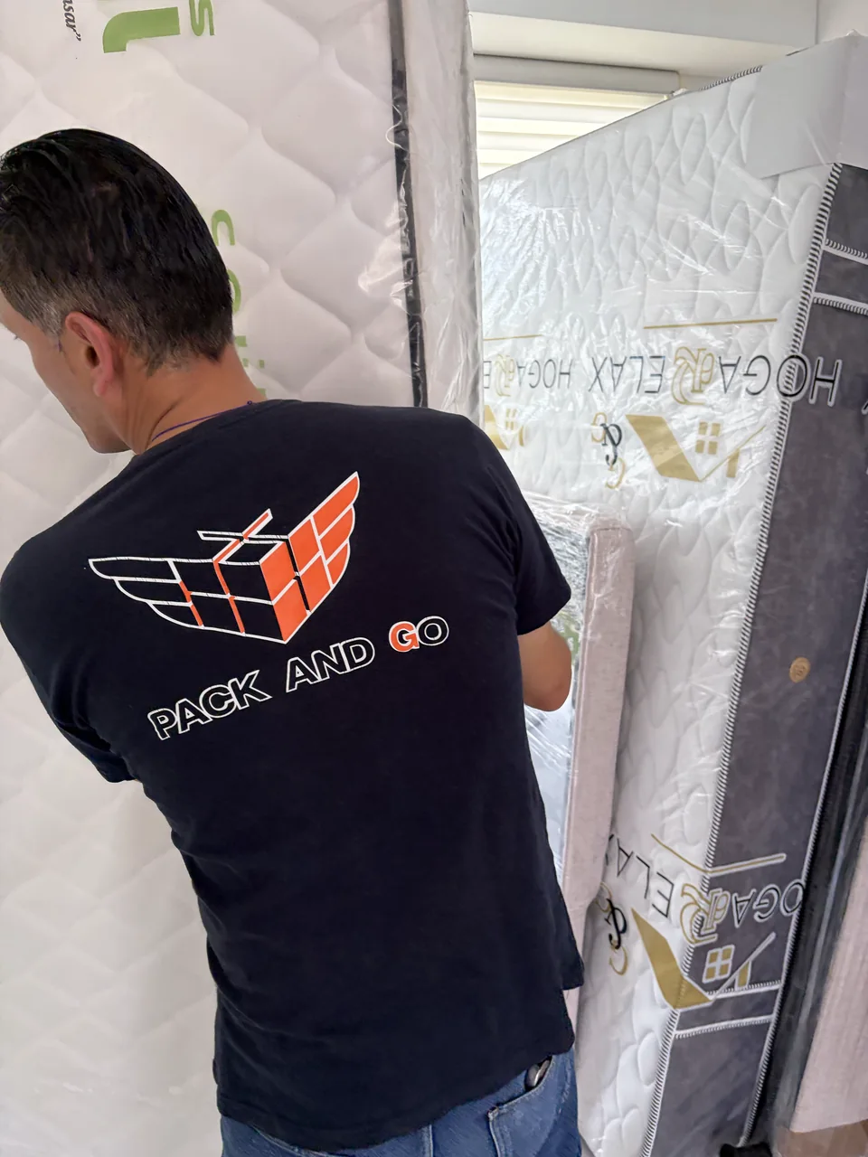 Integrante del equipo preparando muebles protegidos para su traslado